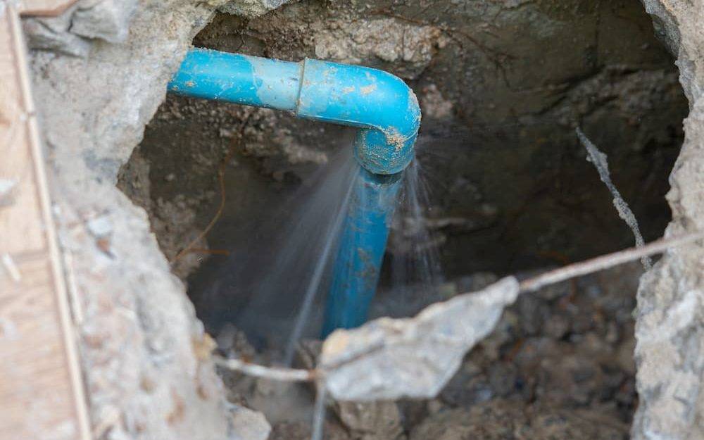 leaking water from blue pipe from underground